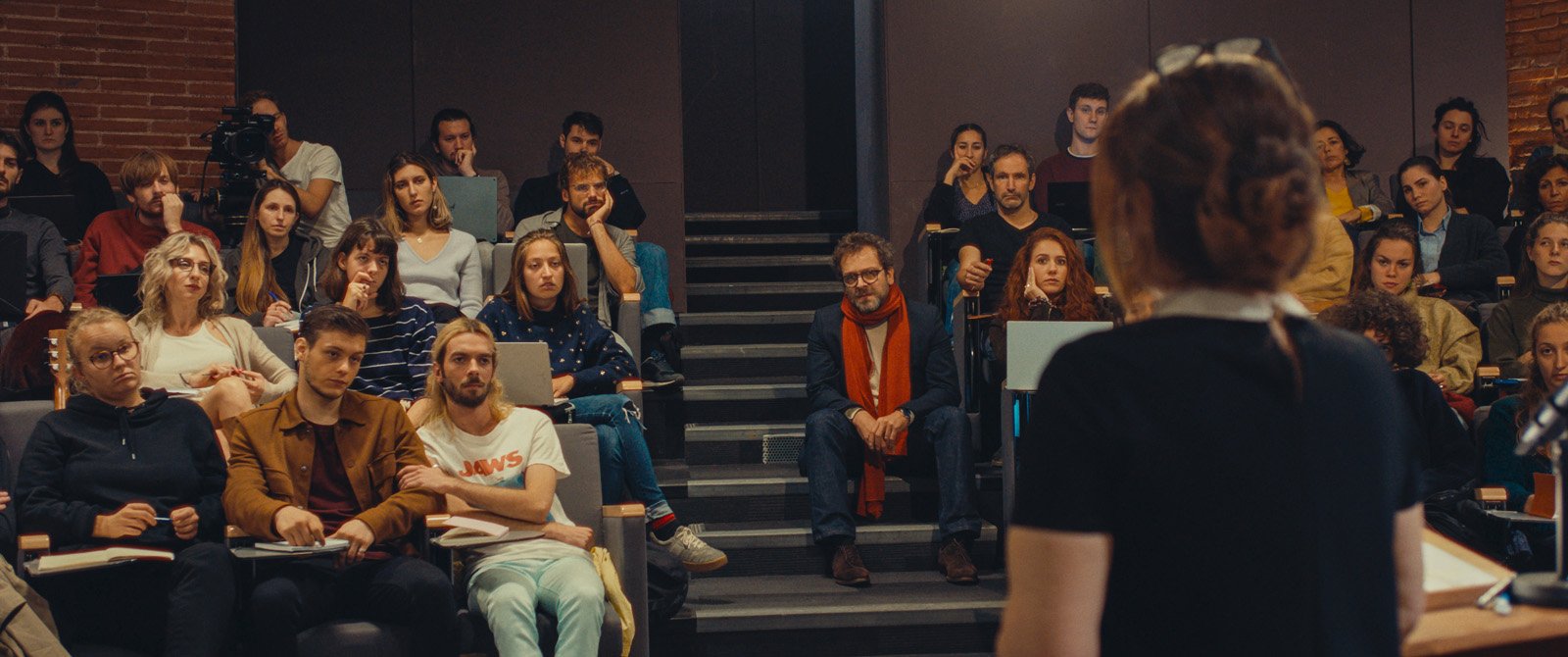 Noémie (Agnès Jaoui) de dos donnant une leçon de cinéma à des étudiants dans un amphi